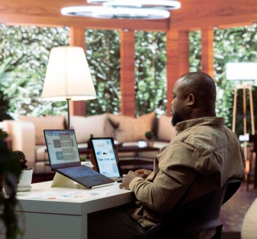 A professional working with a laptop and tablet